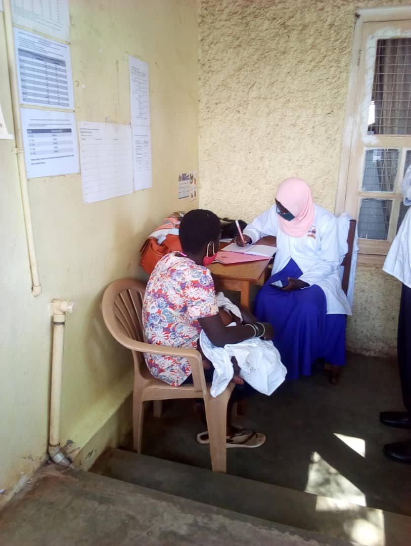 A health worker consults with a mother at a clinic in Uganda